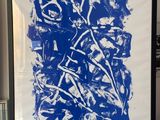 blue and white abstract painting in a black frame in a living room
