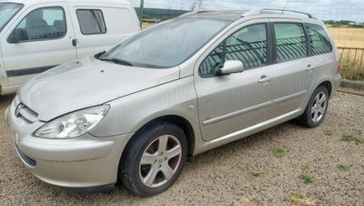 une voiture argentée garée à côté d'une camionnette blanche