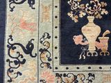 an oriental rug with a vase of flowers on a blue ground