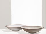 two brown bowls sitting on top of a white table