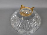 a glass bowl with a gold lid on a table