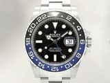 une montre Rolex avec un cadran noir et une lunette bleue