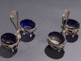 three silver and blue glass bowls and spoons on a table