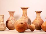 five vases sitting in a row on a white surface