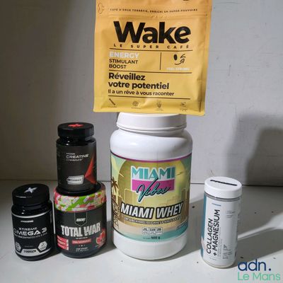 une bouteille de Wake à côté d'un sachet de comprimés et d'un flacon de comprimés