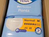 une boîte de culottes de protection Tena posée sur une table