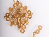 an image of a gold cross and earring on a white surface