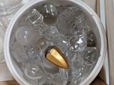 an ice bucket with a gold spoon inside of it