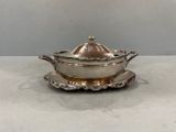 an antique silver plate with a lid and a saucer on it