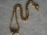 a gold chain with a heart shaped pendant on it