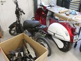 une boîte remplie de trottinettes de toutes sortes dans un garage