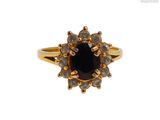 gros plan d'une bague en or avec une pierre noire