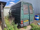 une camionnette verte garée dans une cour