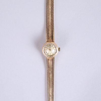 an image of a gold wrist watch with a chain around it