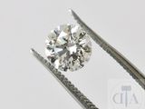 un gros plan d'un diamant tenu par une paire de pinces