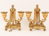 pair of antique brass candelabs on stands on a white background