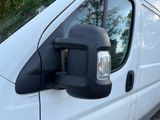 an image of a side view mirror of a white van
