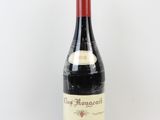 une vieille bouteille de vin posée sur une table blanche