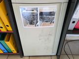 un petit réfrigérateur sur lequel sont posés de nombreux papiers