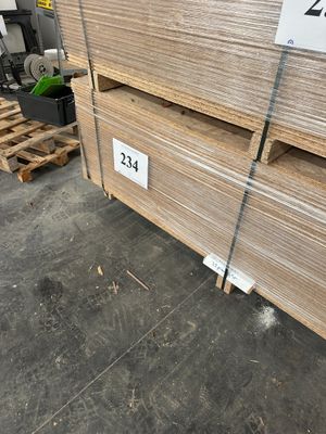plusieurs piles de palettes en bois empilées les unes sur les autres dans un entrepôt