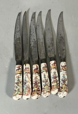six couteaux sont alignés sur une table