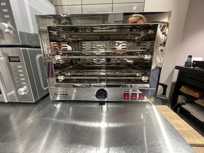 un homme debout devant un four dans une cuisine