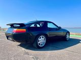 une photo d'une voiture de sport noire garée sur le bord de la route