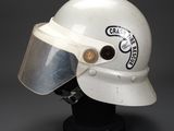 a white helmet with a clear visor on a black stand