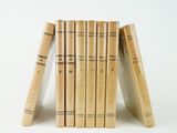 several books stacked on top of each other on a white surface