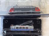 two toy trains sitting in a plastic box on a table