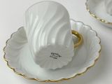two cups and saucers that are sitting on a table