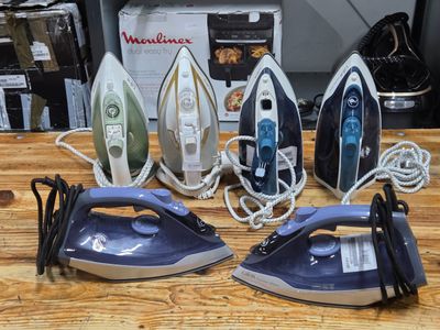 four irons sitting on a table next to each other