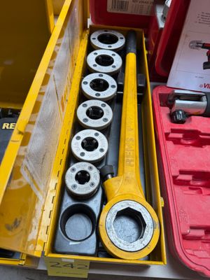 une boîte à outils jaune, contenant des outils, posée sur une table