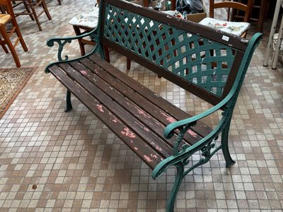 un banc en bois posé sur un sol carrelé dans un restaurant