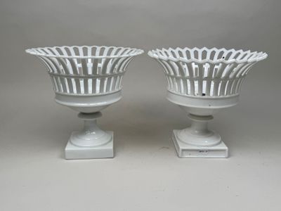 une paire de vases blancs posés sur un socle blanc