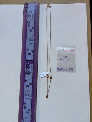 a picture of a necklace and a ruler on a table