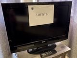 une télévision posée sur une table sur laquelle est inscrit « lot ' n 6 »