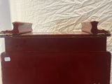 a red suitcase sitting on top of a white sheet