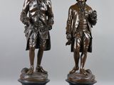 two bronze statues of a man and a woman standing next to each other