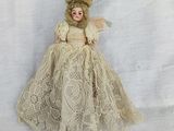an old fashioned doll with a white dress and fur on a white background