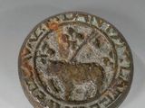 un petit objet métallique orné d'un motif
