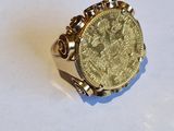 une image représentant une bague sur laquelle repose une pièce d'or