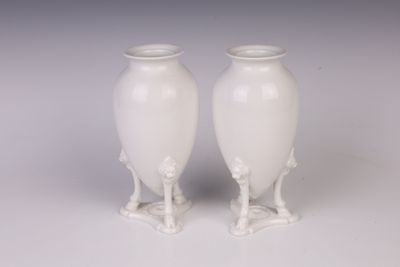 deux vases blancs posés l'un à côté de l'autre sur une table