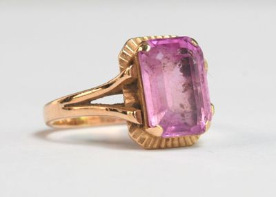 une photo d'une bague en pierre rose avec un anneau en or