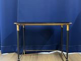 an image of a black and gold table with a blue curtain in the background