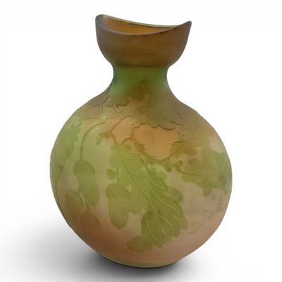 a green and yellow vase with leaves on it