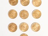 a close up of a number of gold coins on a white surface