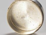 a close up of a silver object on a white surface