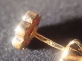 a close up of a pair of gold stud earrings