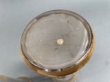 a glass vase with a gold rim and a gold handle